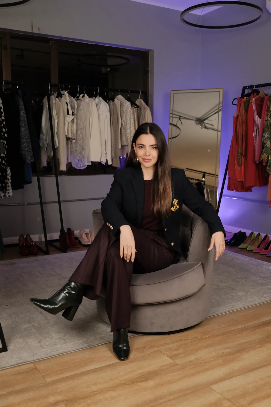Daniela Mateluna en el showroom de DM IMAGE, con percheros de ropa detrás