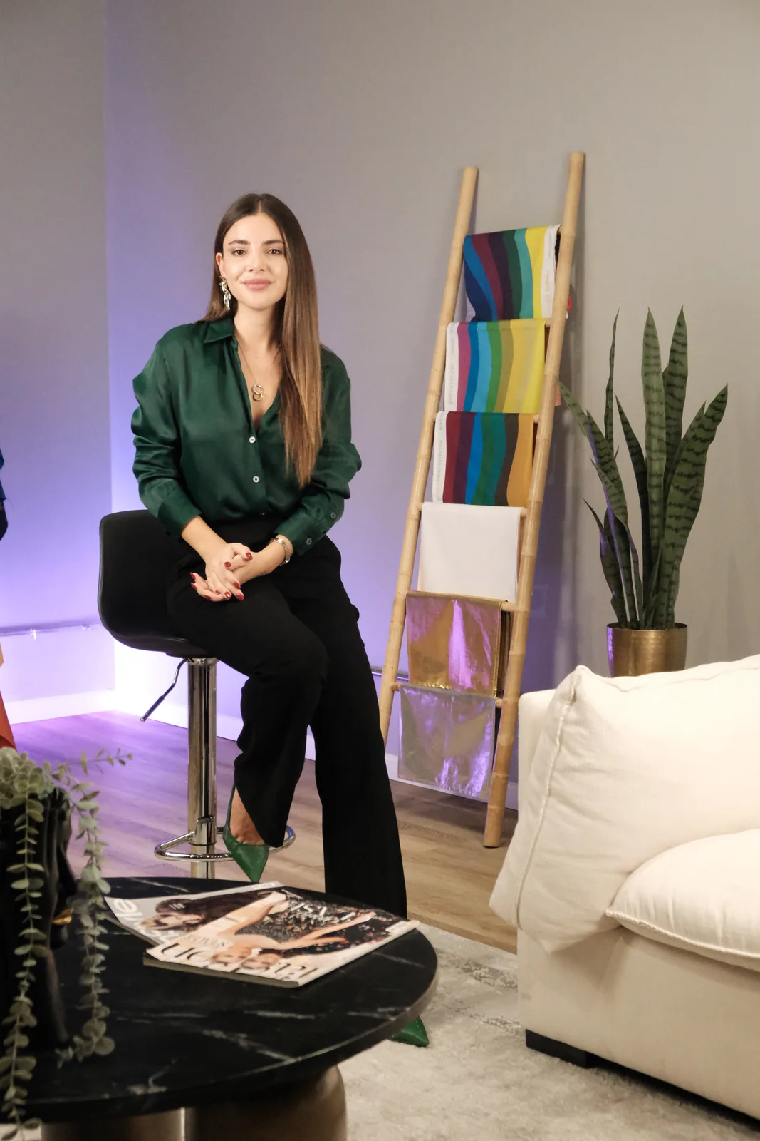 Daniela Mateluna sentada junto a una escalera con telas de colores